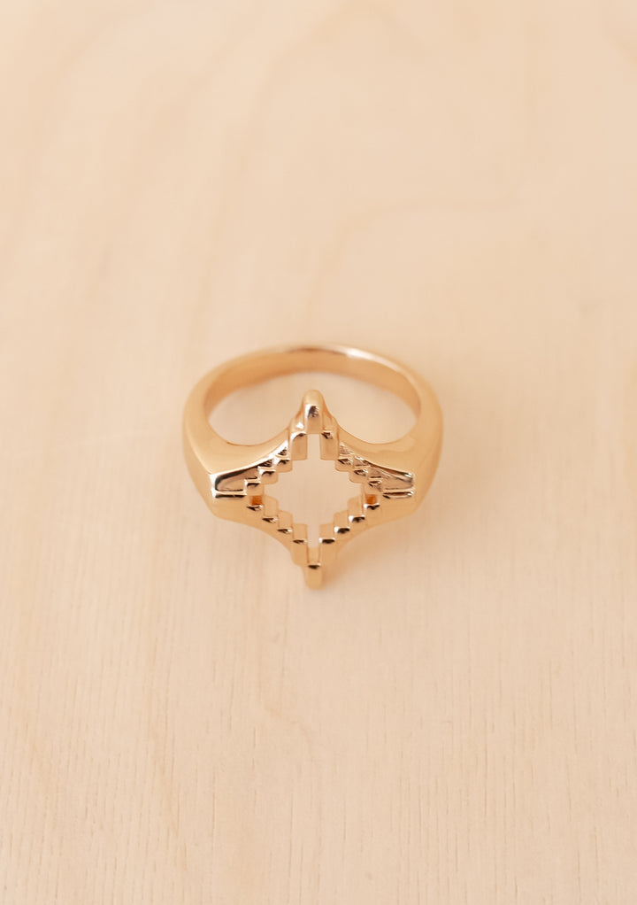 TBCo x frkl. Diamond Scarf Ring on wood surface; gold-tone, pixel-inspired geometric design, ideal for showcasing scarves in bold, expressive styles.