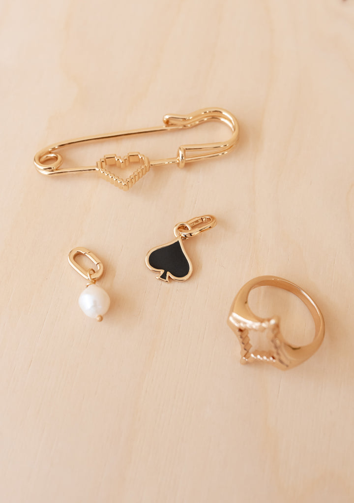 TBCo x frkl. Diamond Scarf Ring featuring a pixelated heart motif, crafted from 18k gold plated brass, shown with coordinating jewelry on a wood background.